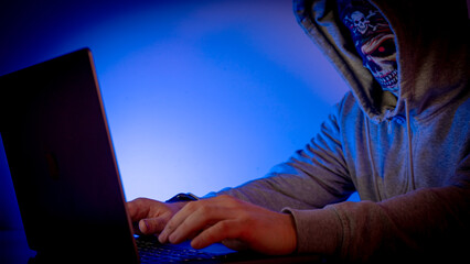 Hacker at laptop in dark room