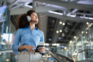 Latino woman walking through airport terminal toward the boarding gate.