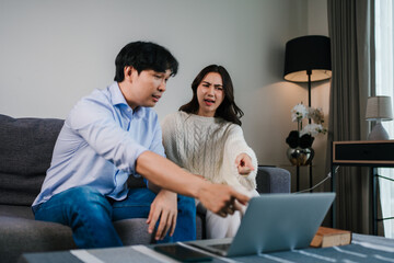 Couple discussing problem while browsing laptop online