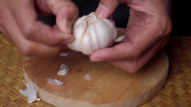 Hands Peeling Fresh Garlic Bulb