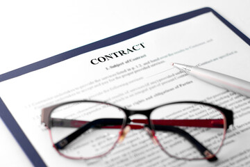 Signing the contract with pen and glasses in business work.