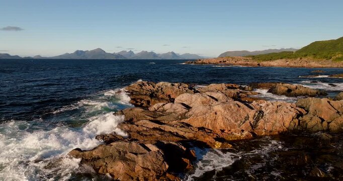 Waves Crashing Against The Rocky Coast Of Stokmarknes In Norway. - aerial shot