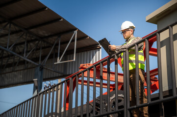 Naklejka premium Professional engineer reviewing inspection checklist at hydraulic infrastructure facility outdoors