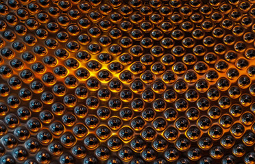 a metallic surface featuring a uniform pattern of raised, circular, button-like protrusions