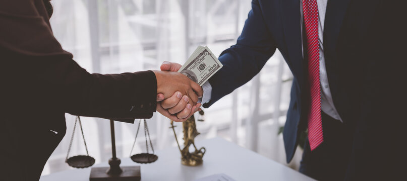 People shaking hands exchanging money as a bribe