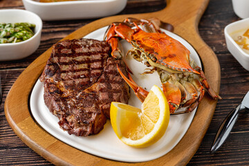 Tenderloin steak served with whole crab and lemon wedge