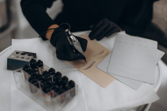 Practicing microblading brow tattoo on training skin