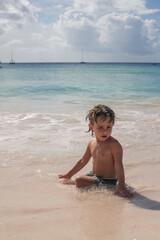 Young boy relaxing in water on caribbean beach