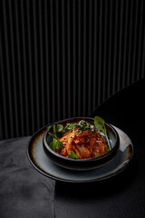 Cabbage kimchi on a plate in a restaurant on a dark background