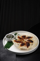 Fried gyoza on a white plate with sauces isolated for menu