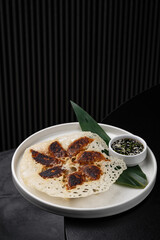 Fried gyoza on a white plate with sauces isolated for menu