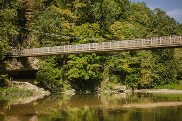 Suspension bridge over river with fall trees at Turkey Run
