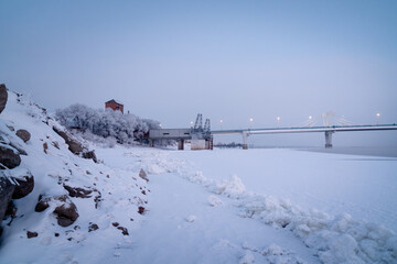 Winter view of an Illuminated bridge crossing the Zeya River in Blagoveshchensk, Russia.