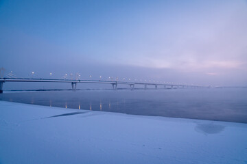 Winter view of an Illuminated bridge crossing the Zeya River in Blagoveshchensk, Russia.