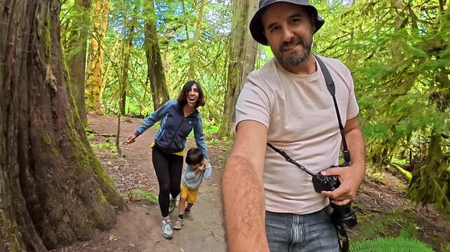 Tourists leisurely walking through verdant old growth forest within cathedral grove nature park, experiencing lush temperate rainforest landscape on vancouver island, british columbia