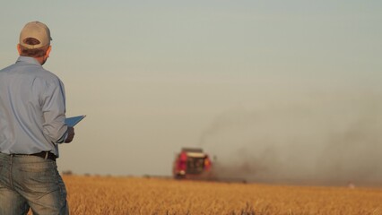 farmer working in wheat field, combine harvester ploughing in wheat field, agriculture tablet, digital tools for farmers, agricultural business strategies, field management via tablet, enhancing