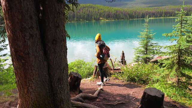 Majestic maligne lake in jasper national park provides a stunning backdrop for a female hiker enjoying the serene beauty of the canadian rockies