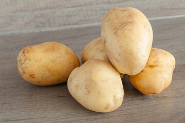 New potatoes piled high on a rustic wooden table. Natural, pesticide-free, and non-GMO, these are perfect for the home kitchen.