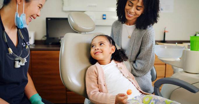 Smile, kid and consultation with dentist in office for dental checkup, tooth extraction and hygiene. Mother, child and hygienist with lollipop of oral health, teeth whitening and cleaning services