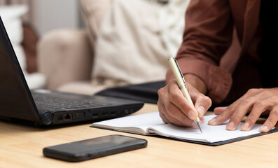 Fototapeta premium young man writing on notebook while online learning at home, online course, e- lerning concept