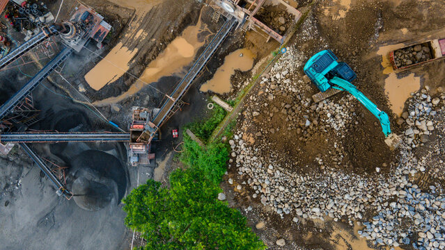 Excavator Operating in Rock Crusher Facility. Construction and Mining site view from above
