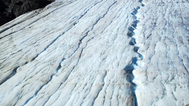 Snowy footprints winding across pristine surface of athabasca glacier, revealing human presence within vast columbia icefield landscape of jasper national park's winter wilderness