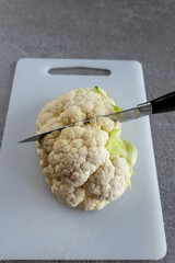 Cauliflower vegetable preparation on white cutting board