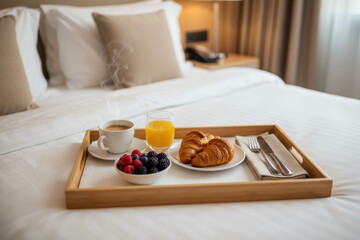 Delicious hotel breakfast on a wooden tray with coffee and fresh berries