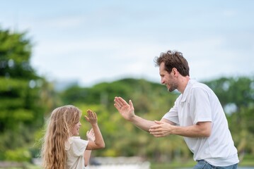 Obraz premium Happy Father and Daughter Celebrating with High Five Achievement in Active Family Life in Park. father and daughter high five moment joyful gesture emotional bonding moment outdoors