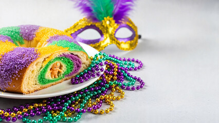 Naklejka premium King cake slice with Mardi Gras beads and mask on a festive background, with copy space