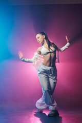 Neon jazz funk hip hop dancer posing in blue and pink studio lighting