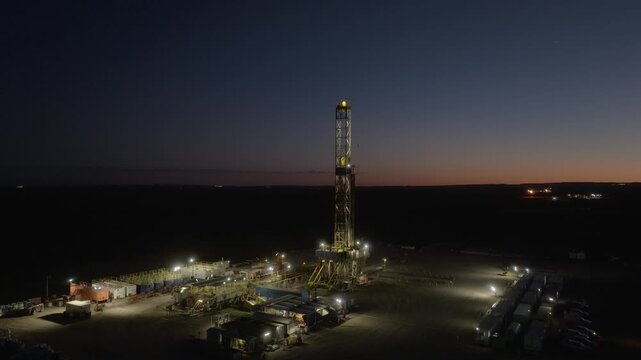 Beautiful drone shot smoothly circling an oil derrick in Vaca Muerta. Drilling rig in production. Sunrise in A&ntilde;elo. 4K