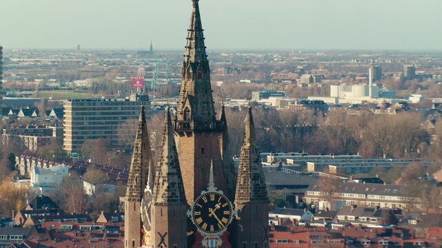 European Dutch city town landscape cityscape view from high angle with traditional authentic architecture buildings in Netherlands during sunny day in Delft with tower spire and clock, zoom in scenery