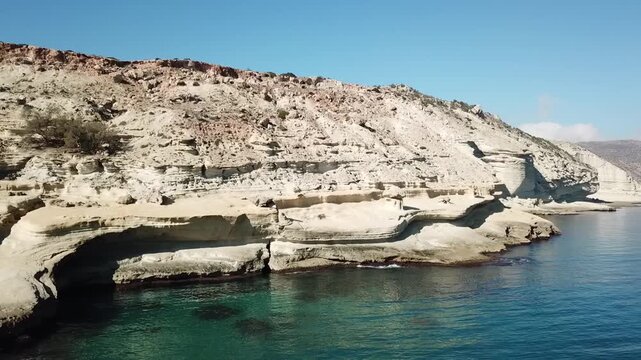 Close-up drone shot of a traditional Moroccan mosque minaret overlooking the city of Nador and the calm waters of Mar Chica lagoon.