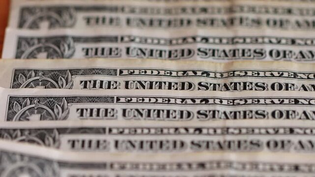 Macro view of one-dollar banknotes arranged in a row, representing the concept of the foreign exchange market and the strength or devaluation of the US dollar.