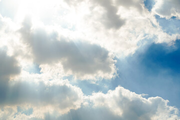 Obraz premium Bright Sun Rays in Blue Sky with Sunshine and Light Beams Through Clouds
