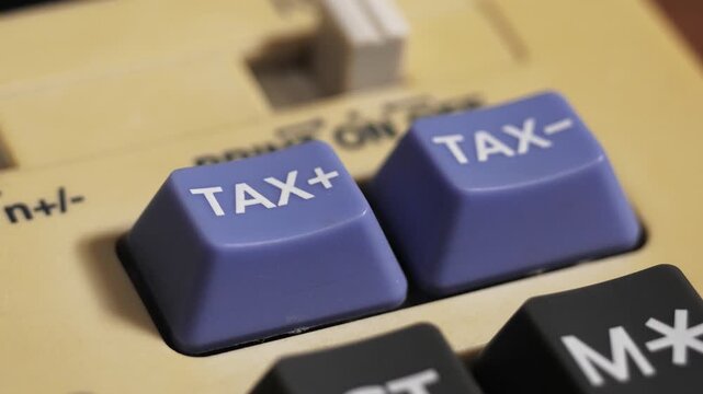 Close up of finger pressing tax plus then tax minus on a vintage calculator