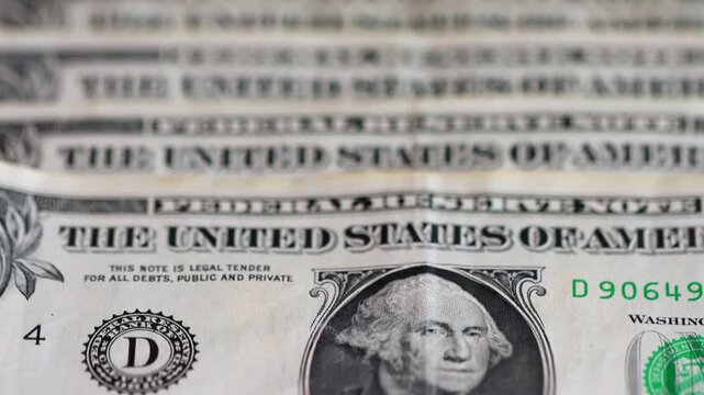 Macro view of one-dollar banknotes arranged in a row, representing the concept of the foreign exchange market and the strength or devaluation of the US dollar.