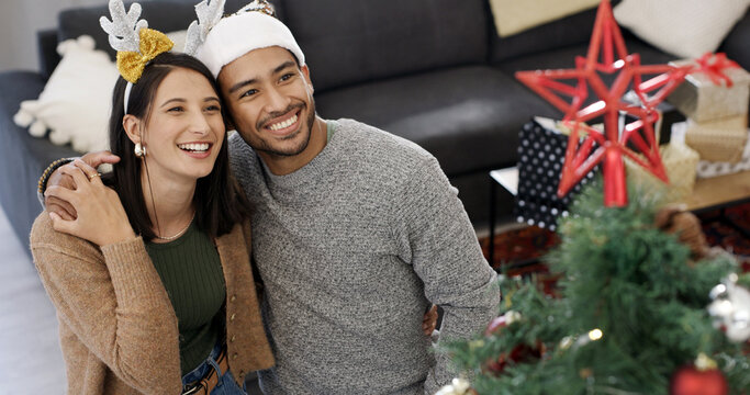 Christmas tree, hug and couple with smile, home and bonding together with decoration. Xmas, man and woman in lounge, apartment and embrace with happiness, festive season and tradition with holiday - Powered by Adobe