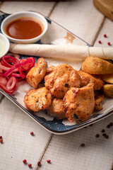 Grilled chicken kebab pieces served with flatbread pickled onions and creamy sauces on a rustic plate