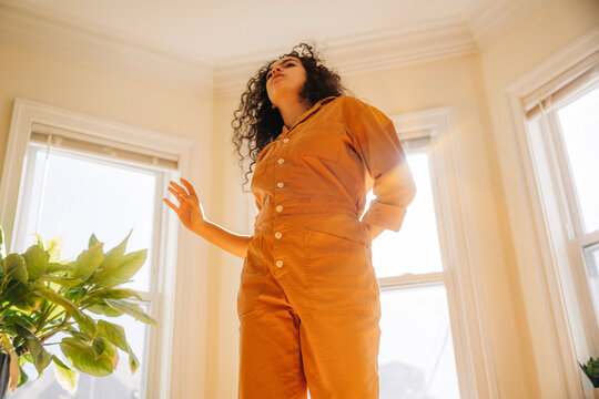 Woman standing confident in jumpsuit catching sunlight