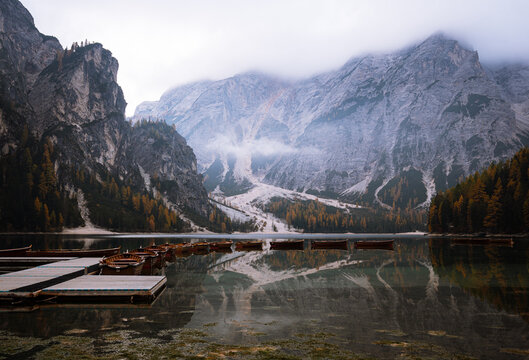 Wooden boats at Lago di Braies with alpine mountains in autumn
