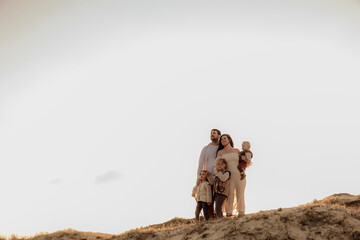 Silhouetted family walking along a dune ridge at sunset