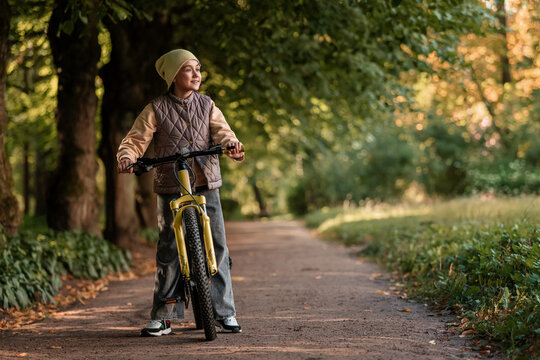 Happy kid enjoying bike ride in nature on a sunny day.