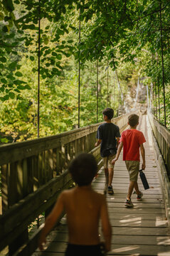 Three boys walk across suspension bridge at Turkey Run State Park