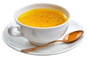White ceramic cup filled with golden yellow broth and a bronze spoon soup liquid