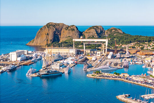 Industrial maritime port with cranes, docks, and yachts in La Ciotat on the Mediterranean coast. Southern France coastal city