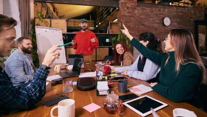 Coworkers brainstorming ideas in startup office environment. Concept of startup collaboration, idea discussion and creative teamwork inside modern work space.