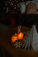 Festive home decor. Christmas tree, burning candles. New Year.