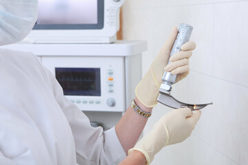 Laryngoscope for oral tracheal intubation in the hands. The hands of an anesthesiologist-resuscitator. Performing resuscitation, ventilation, and general anesthesia. The concept of healthcare.